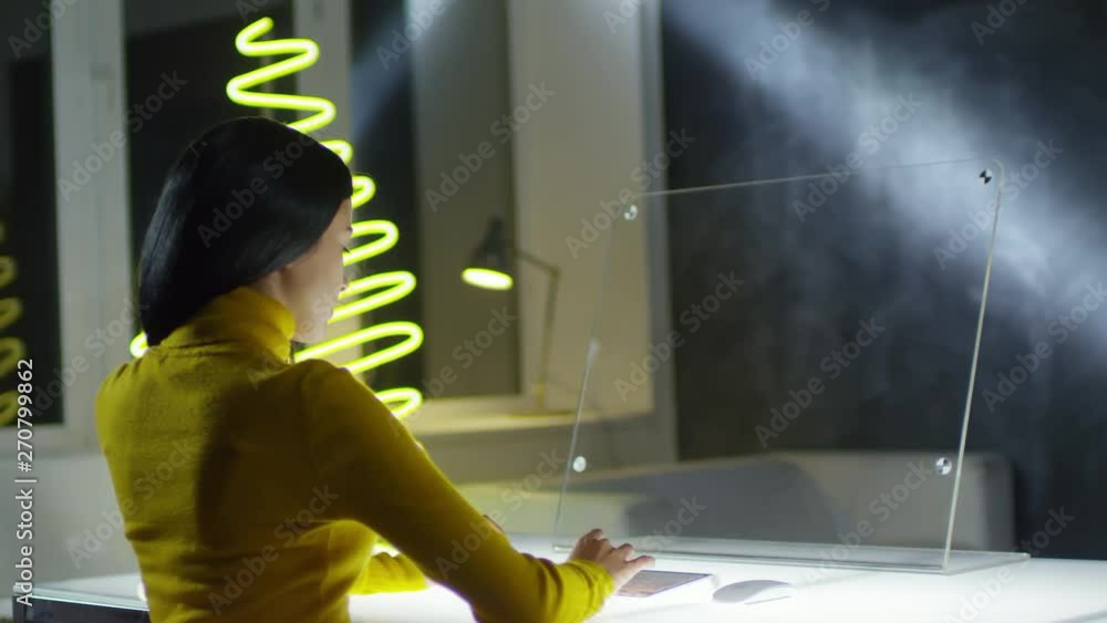Aufkleber rare view of young asian woman sitting at invisible ar screen of futuristic computer and typing on w