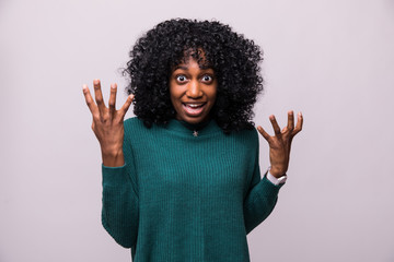Enraged young curly african woman with hands up yelling isolated on white background