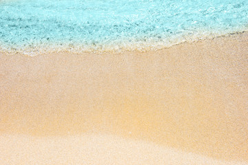 Soft wave of turquoise sea water on the sandy beach