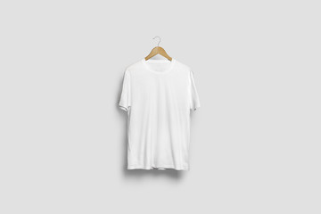 Blank soft gray T-Shirt Mock-up hanging on white wall, front side view. Ready to replace your...