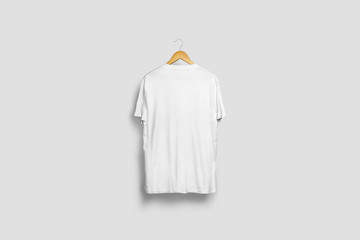 Blank soft gray T-Shirt Mock-up hanging on white wall, back side view. Ready to replace your...