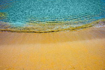 Soft wave of turquoise sea water on the sandy beach