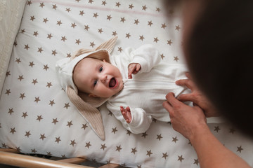 Cute baby in the rabbit costume lying in the bed.