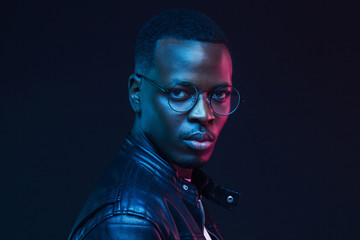 Neon futuristic portrait of handsome african american young  male model wearing trendy eyeglasses