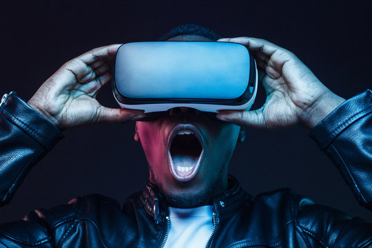 Fototapeta Headshot of excited young african american man enjoying virtual reality with mouth wide open