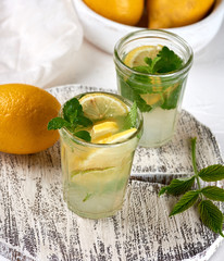refreshing drink lemonade with lemons, mint leaves, lime in a glass