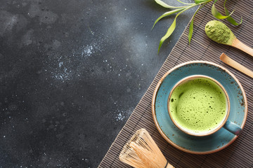 Organic green matcha tea on black table. Top view. Space for text.