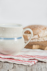 Slices of fresh wheat bread and Cup of milk on vintage tablecloth