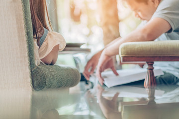 Asian man read a book in a coffee shop. Selective focus on female.