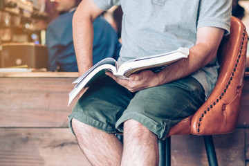 Fototapeta premium Asian man read a book in a coffee shop.