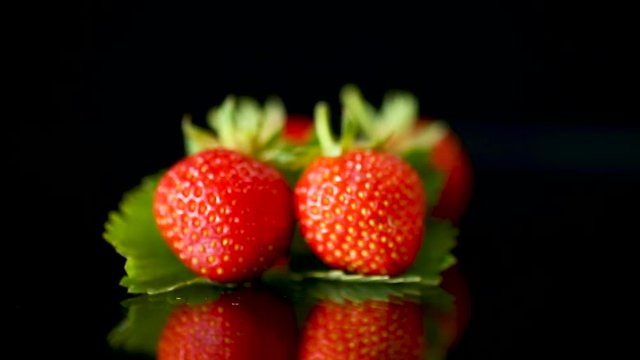 ripe red strawberries on a black background