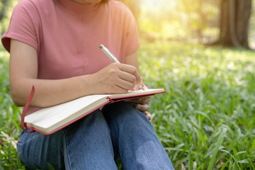 poem, poetry and knowledge education concept,  close up sitting writing on notebook in park