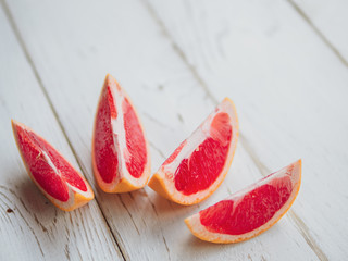 Fresh summer grapefruit slices composition on white wooden planks background