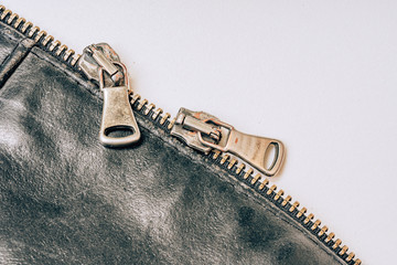 Steel zipper on a leather jacket on a white background. Metal clasp on the jacket. Iron strong...