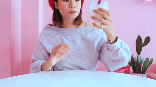 Young Asian Millennial Woman Drinking Iced Bubble Milk Tea In Pink Pastel Cafe