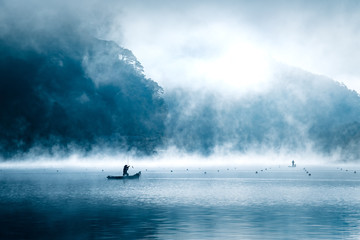 catching a fish a sunrise in the mist of lake shoji