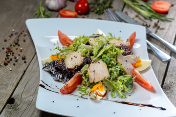 Caesar salad in a beautiful author's presentation from the sheva on a square plate on a wooden background