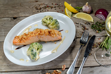 salmon steak on white plate on wooden background
