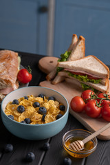 Traditional breakfast. Healthy food. Organic lunch. Delicious snaсk - baguette with cheese and tomato, sandwich with salad and meat. Black table. Kitchen