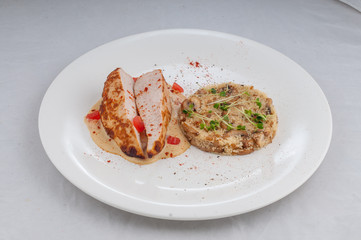 chicken with porridge in a beautiful atorsky serve from the chef on a white plate on a white background