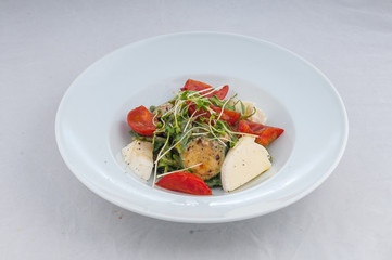 salad with cheese and grilled waxes on a white plate on a white background