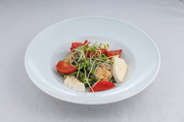 salad with cheese and grilled waxes on a white plate on a white background