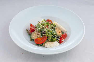 salad with cheese and grilled waxes on a white plate on a white background