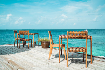 wood table and chair with sea view background in Maldives