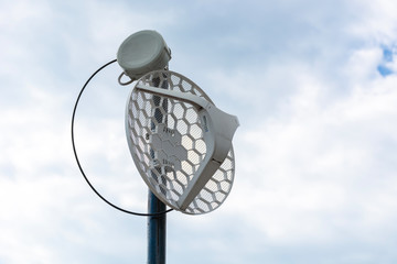 Internet outdoor wireless antenna metal rod on the roof and cloudy sky in the background. Modern technology and internet concept. Close up, selective focus