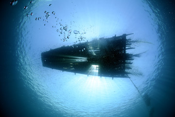 Fishing platform-raft on the ocean surface, the view from under the water. Underwater wide angle photography. Underwater background. Tulamben, Bali, Indonesia. 