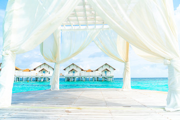 white arch with tropical Maldives resort and sea