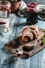 breakfast, croissant and jam, on a blue wood table