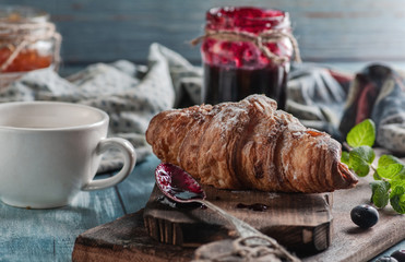 breakfast, croissant and jam, on a blue wood table