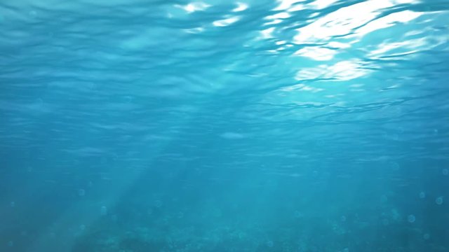 Blue underwater summer background with sun rays