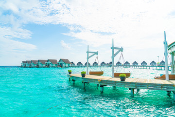 Fototapeta na wymiar sofa swing with tropical Maldives resort and sea background
