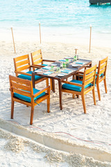 wood table and chair on beach with sea view background in Maldives