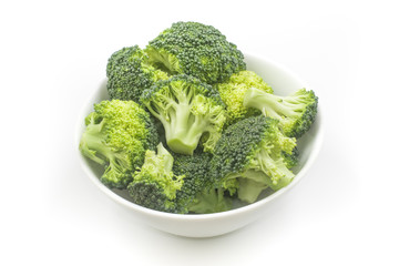 Broccoli sliced into small pieces in a white bowl