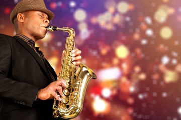 Close-up man playing on saxophone on blurred