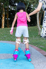 Asian Chinese little girl playing with roller skates
