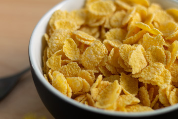 corn flakes on wooden table at morning 