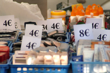 Market stall with cheap cosmetic products and price tags in Euro