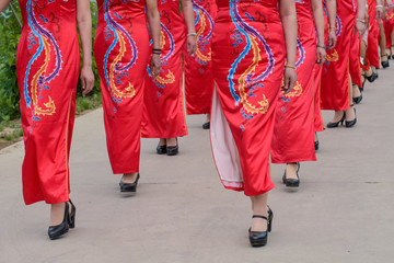 The women in the cheongsam are walking