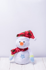 Funny snowman in a red hat and scarf on a white background