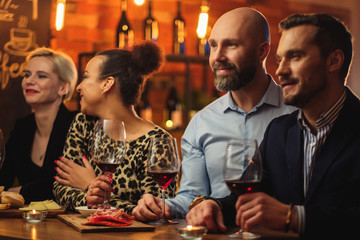 Group of friends having fun talk behind bar counter in a cafe