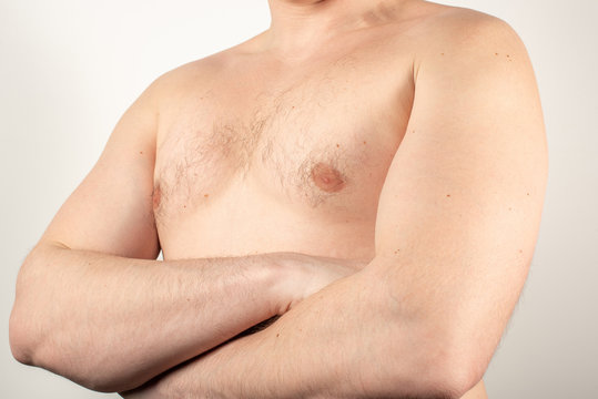 Closeup of chest with hair and crossed arms on white background