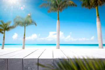 Table background of free space for your decoration and summer palms with sea 
