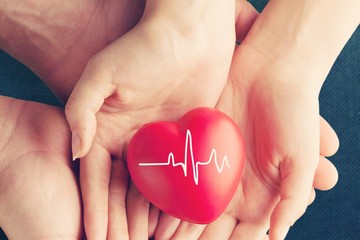 Man and woman holding red heart
