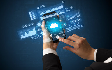 Female hand using smartphone with financial tracking concept illustrated by graphs and symbols