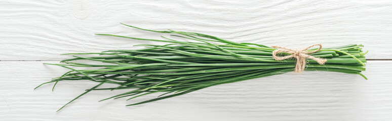 top view of fresh green onion on white wooden table, panoramic shot