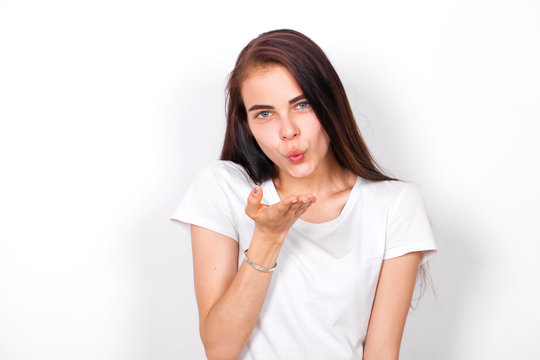 Blow kiss, young caucasian brunette woman